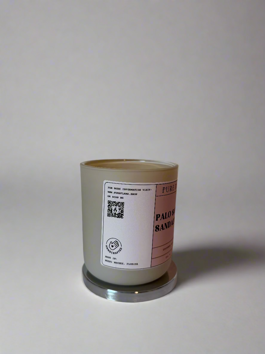 Candle with a label on a white surface and wall background